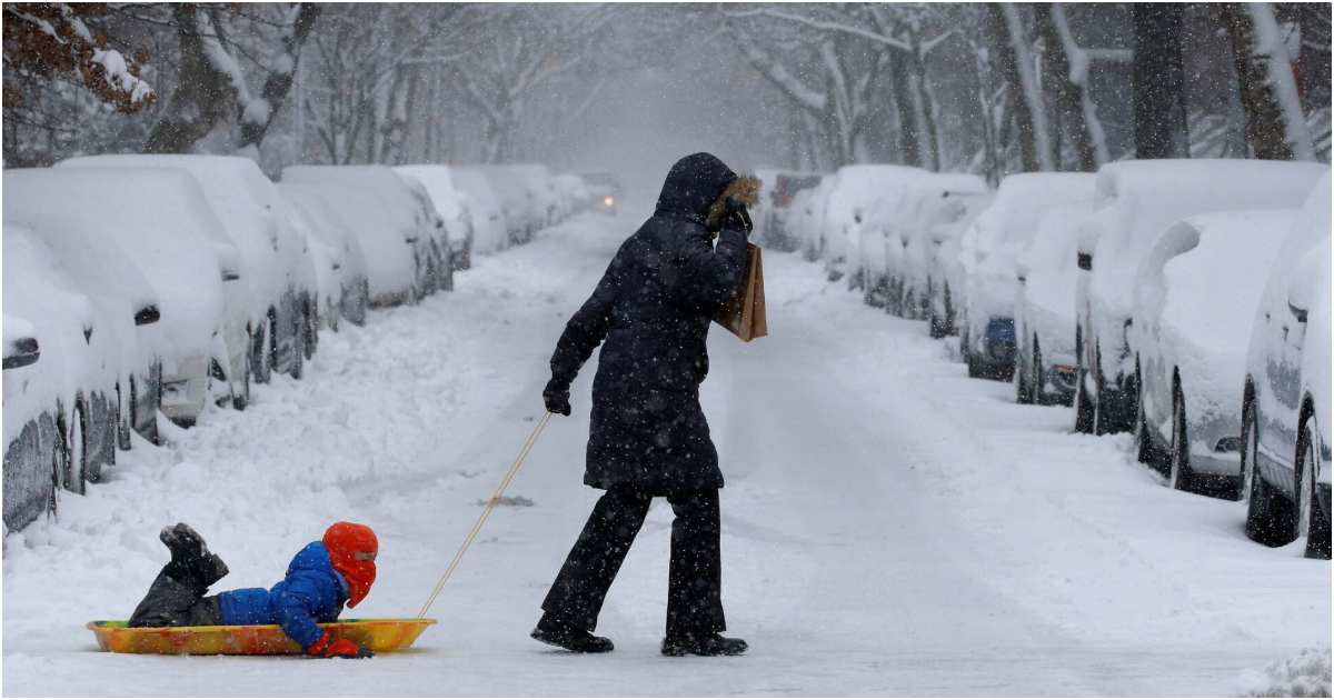নিউ ইয়র্ক সিটির ব্রুকলিনে ২০১৭ সালের ১০ ফেব্রুয়ারি প্রবল তুষারপাতের মধ্যে একটি স্লেডে করে সন্তানকে টেনে নিয়ে যান এক নারী। ছবি: রয়টার্স